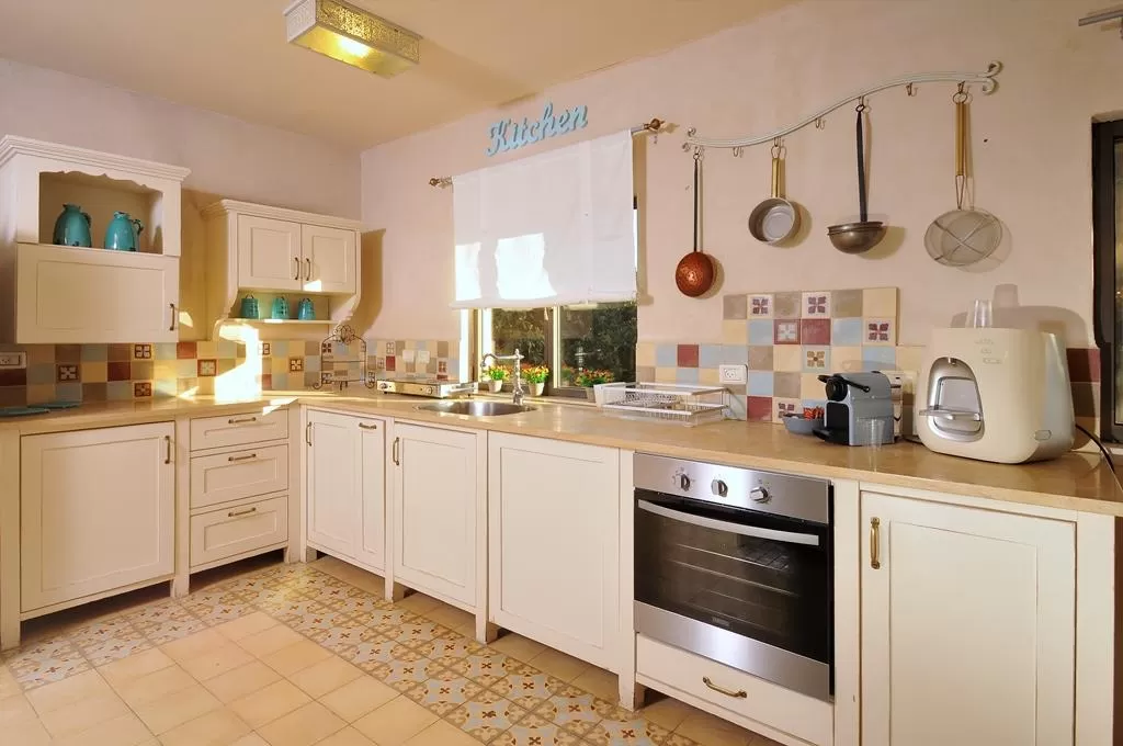 מטבח מסורתי עם ארונות עץ, אריחי קרמיקה ומתקן תלייה לסירים - אחוזת ליאון | lyon, וילה בצפון, יסוד המעלה, גליל עליון