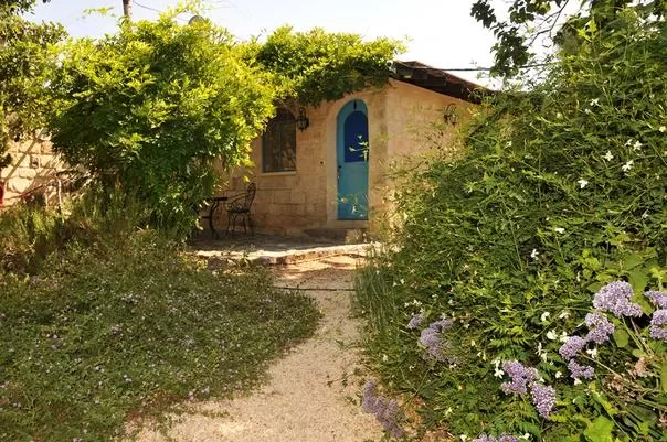 כניסה אבן עם דלת קשת כחולה, גן פרחי פורח - אחוזת ליאון | lyon, וילה בצפון, יסוד המעלה, גליל עליון