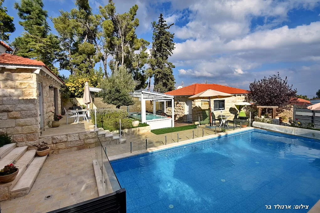 A swimming pool and a green environment of trees and vegetation - Monroe | Boutique Suite, Safed, Upper Galilee