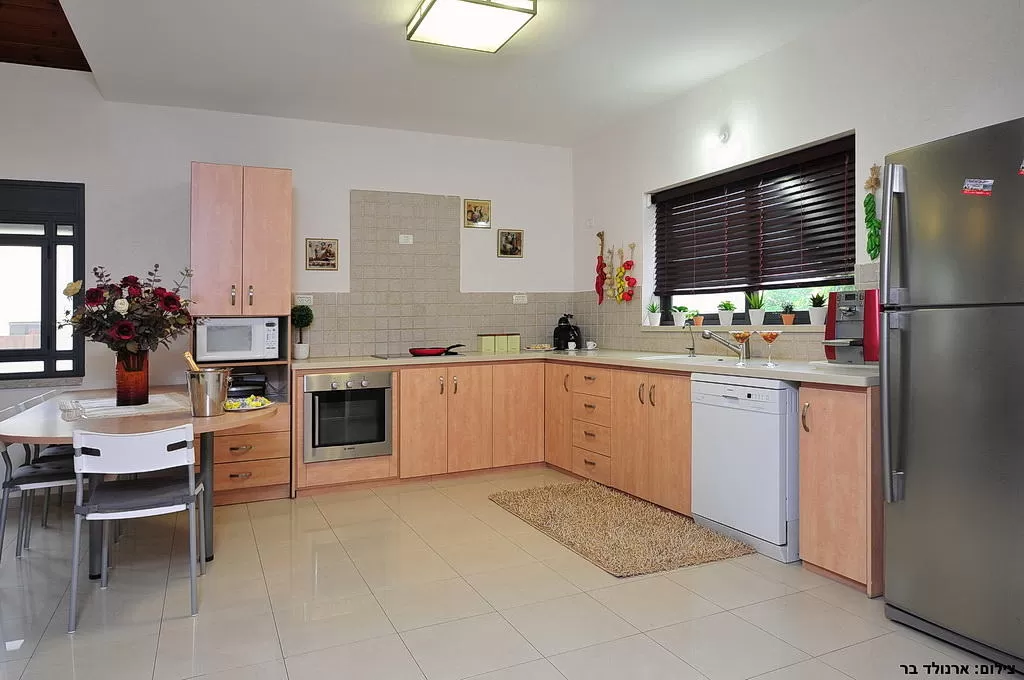 מטבח מודרני עם ארונות עץ, מכשירי נירוסטה, שולחן אוכל וכיסאות בספסופה - וילה מור ולבונה, וילה בצפון, ספסופה - כפר חושן, גליל עליון