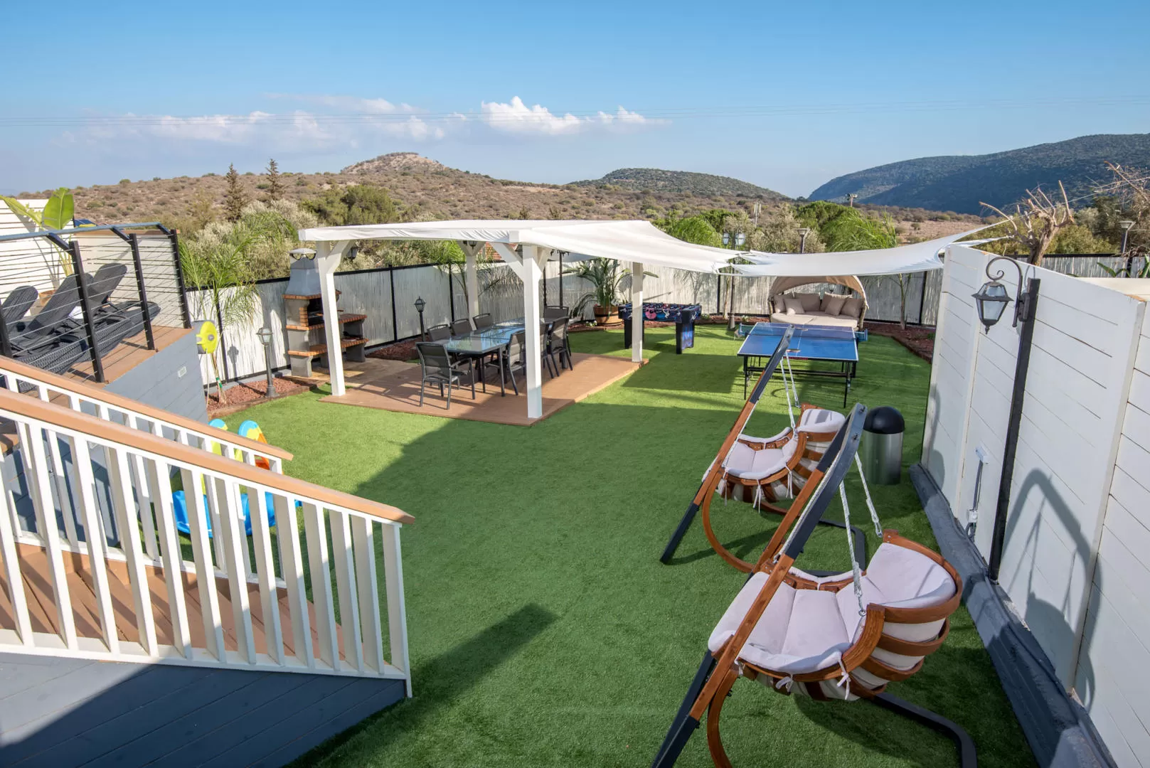 יש כאן חצר משותפת נהדרת, עם מגוון פינות ישיבה, נדנדות והכל מול נוף מדהים מוקף הרים - אחוזת נטלי, וילה בצפון, דישון, גליל עליון