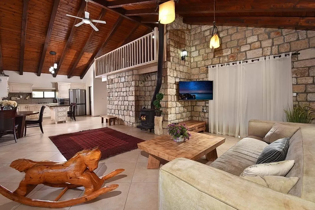 The first thing you notice upon entering the villa is the large brick wall that blends beautifully with the high wooden ceiling in the room - Villa BaKarmim