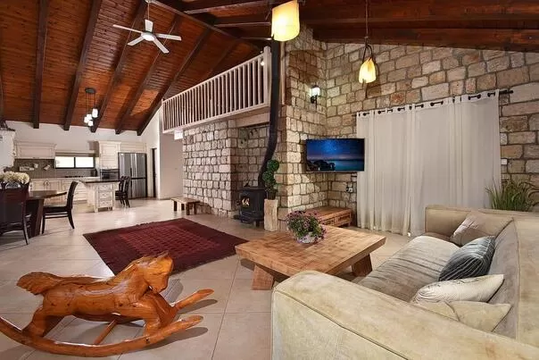The first thing you notice upon entering the villa is the large brick wall that blends beautifully with the high wooden ceiling in the room - Villa BaKarmim