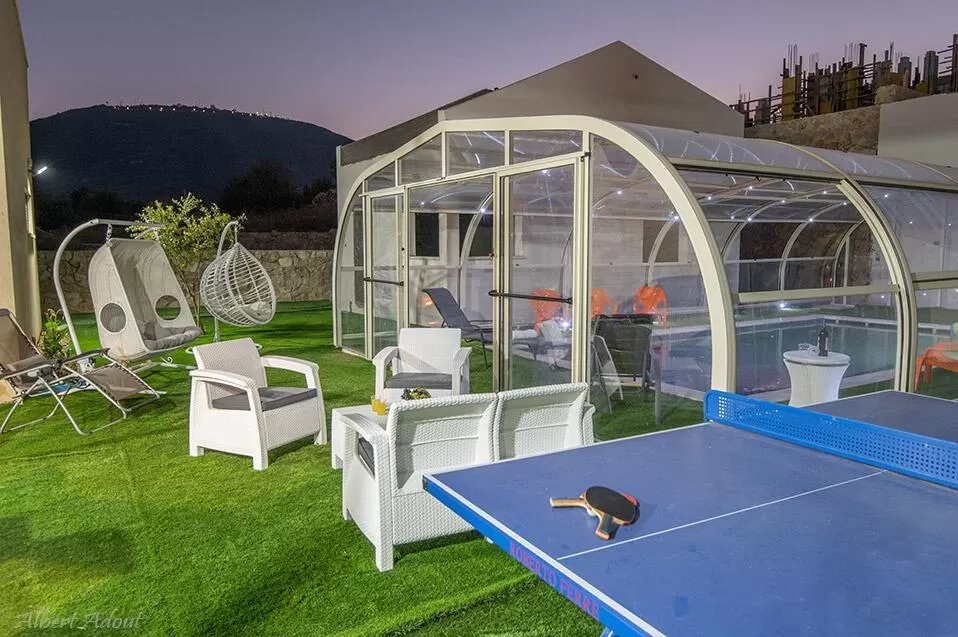 Between the two suites is the indoor pool and the shared outdoor area, with seating areas, hammocks and a ping pong table - Shalvat Anhal, Upper Galilee
