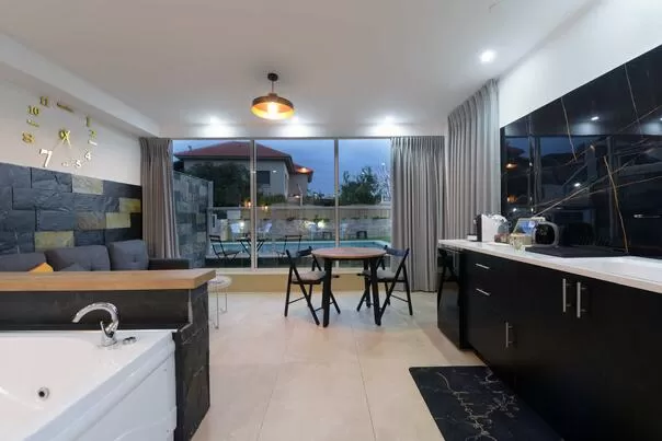 מטבח מודרני וסלון עם חלונות גדולים המשקיפים על אזור בריכה - אל ויסו ורדה, אתר נופש בצפון, חד נס, רמת-הגולן והחרמון