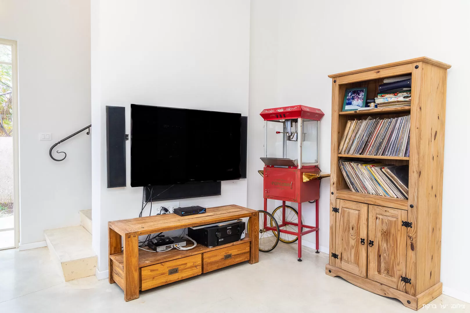 In the living room there is a library with records and a turntable, and a surprising popcorn machine for decoration - Atzel Tali, Hof Habonim, Carmel Beach