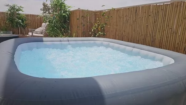 ג'קוזי ספא חיצוני עם בועות, ספסל גינה וצמחייה ירוקה בקצרין - סקנד פלור, סוויטה בצפון, קצרין, רמת-הגולן והחרמון