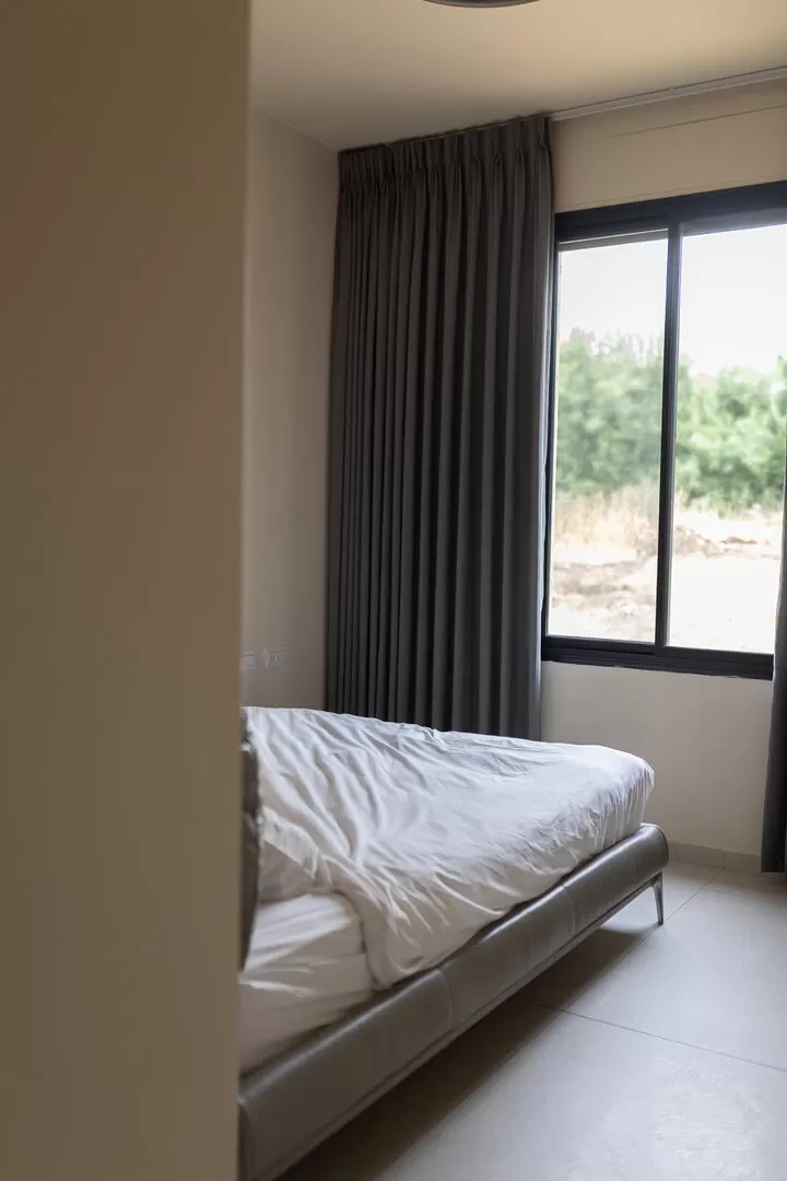 חדר שינה מינימליסטי מודרני עם חלון גדול המשקיף על עצים ויישוב מגדל - בארות מזל, וילה בצפון, מגדל, סובב כנרת